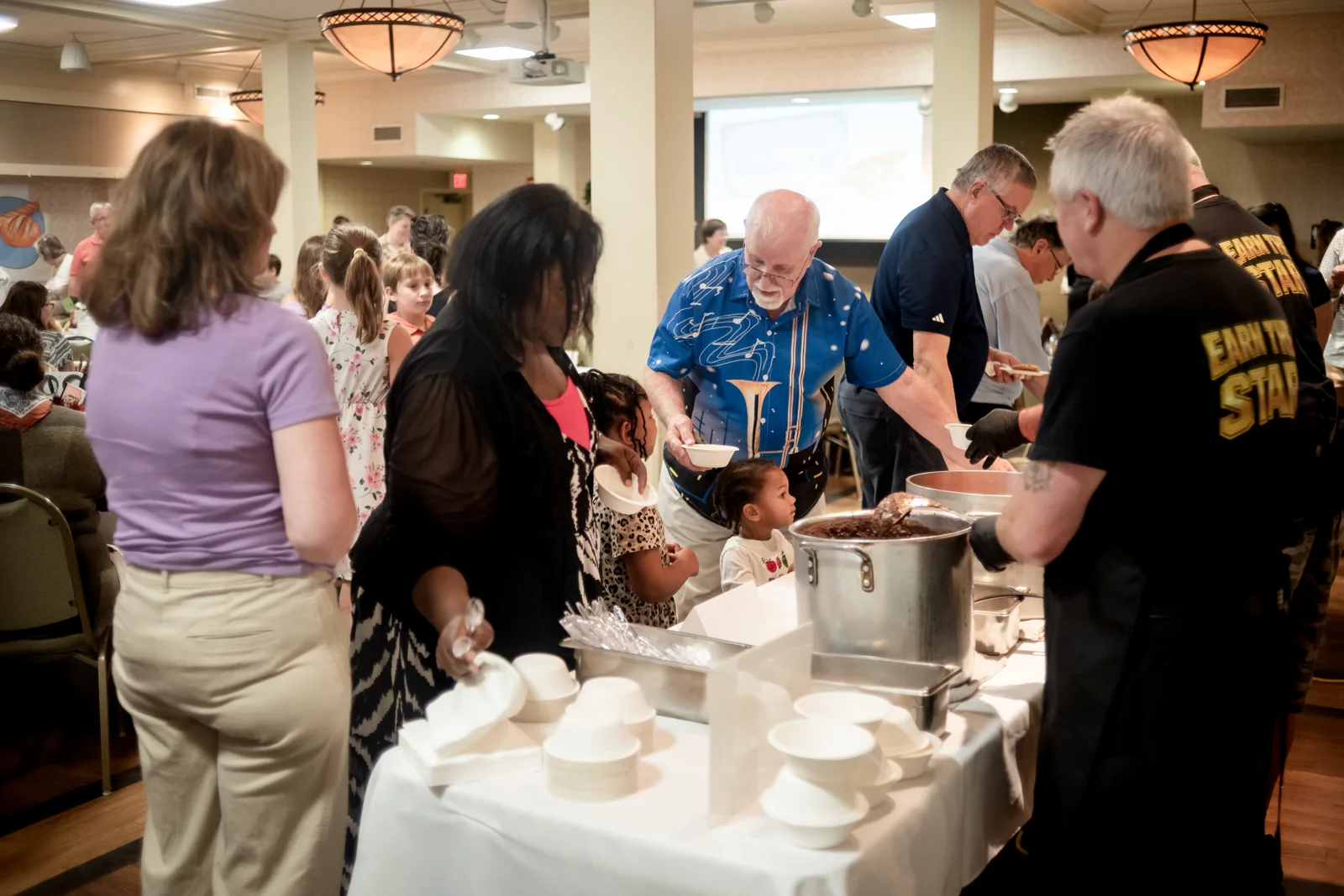 Volunteers serve guests at the supper table